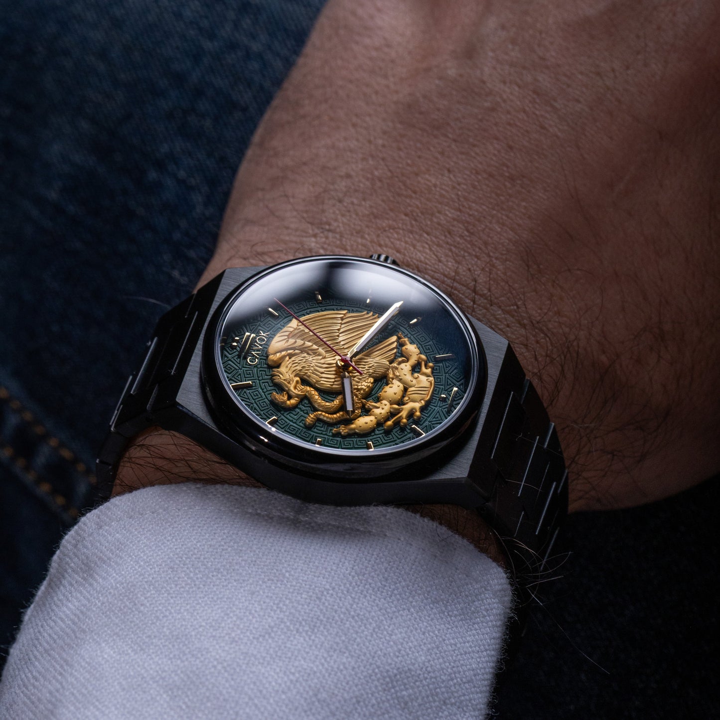 Close-up of a wrist wearing a Mexican Eagle watch with a detailed face, close-up shot.