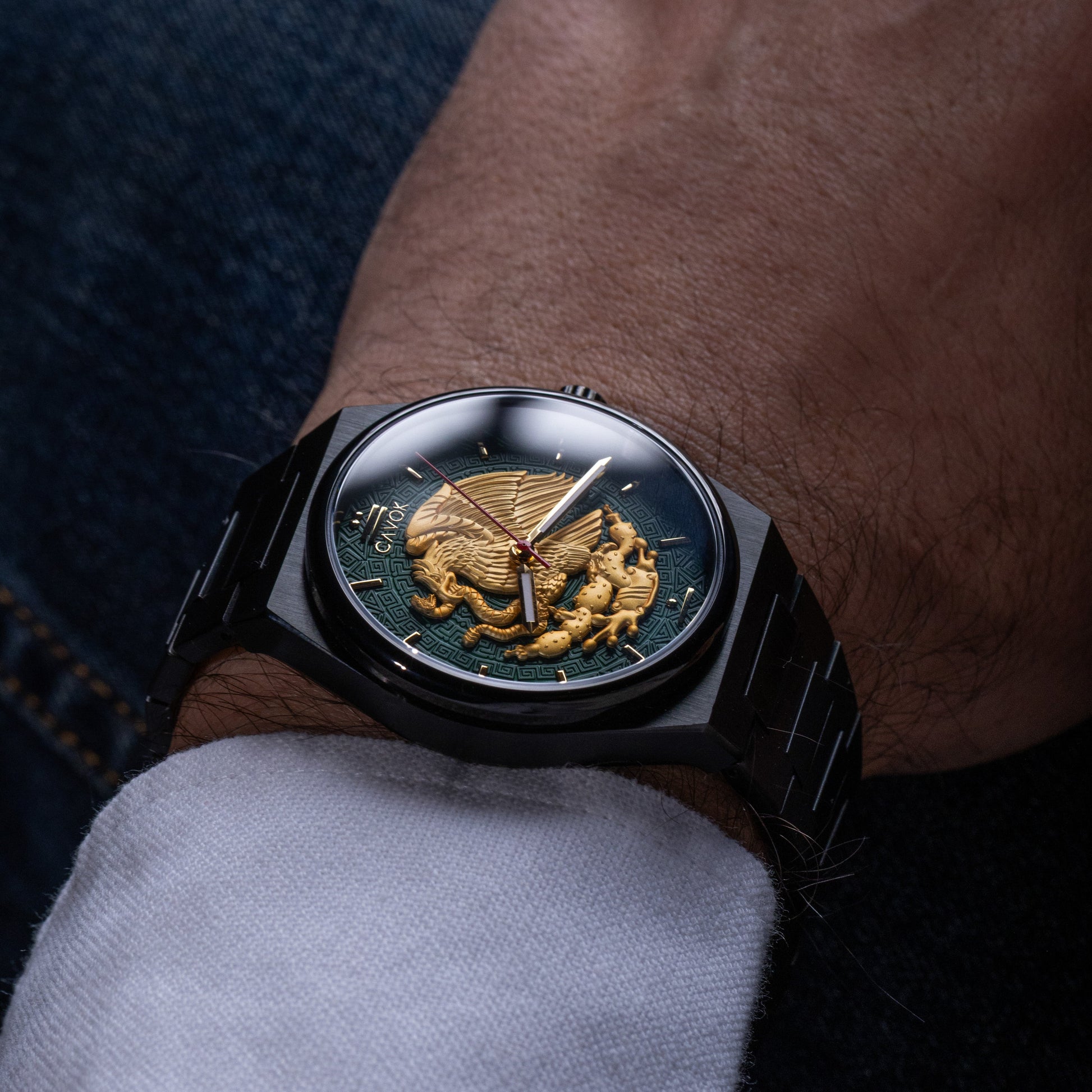 Close-up of a wrist wearing a Mexican Eagle watch with a detailed face, close-up shot.