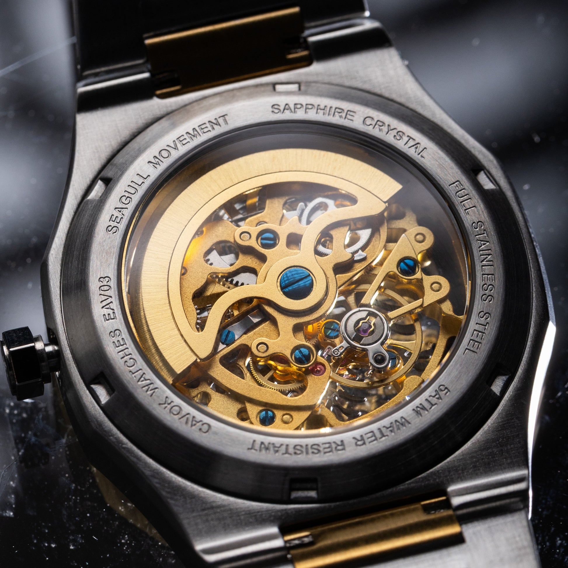 Close-up of a mechanical watch with a metallic band on a dark background